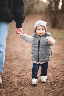 Genç bir anne ve küçük tatlı oğlu baharda parkta yürüyorlar.