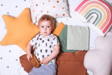 Mutlu bebek çocuk, çocuk odasında yerde duran tahta bir oyuncak arabayla oynuyor.