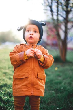 Doğanın arka planında salyangoz yünü şapkalı bir çocuğun portresi.