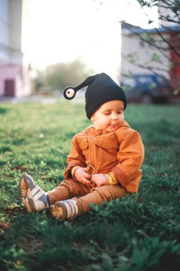Doğanın arka planında salyangoz yünü şapkalı bir çocuğun portresi.