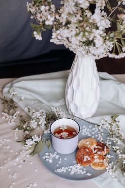 Bahar sağlıklı kızarmış peynirli kekler, çiçek açan beyaz çiçeklere karşı.