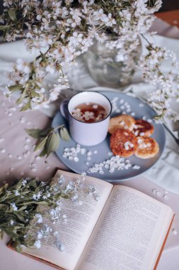 Sabah kahvaltısı, kızarmış güzel peynirli kekler, masa örtüsünün üstünde, bahar çiçeğinin yanında.
