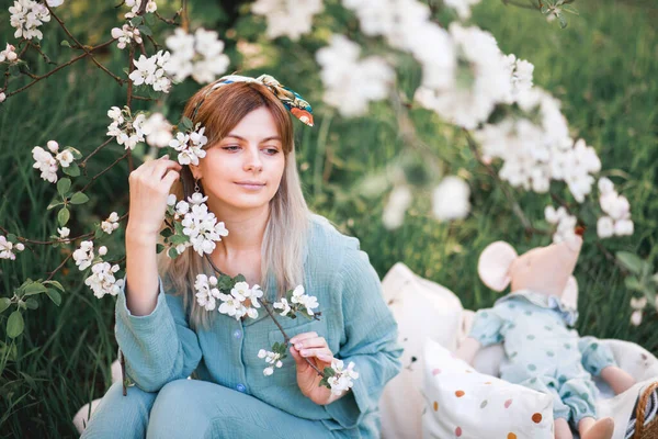 Uzun Saçlı Mavi Pijamalı Bir Kız Baharda Beyaz Çiçeklerin Açtığı — Stok fotoğraf