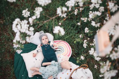 Güneşli bir bahar gününde, çiçek açan elma ağacının altında tatlı bir çocuk..