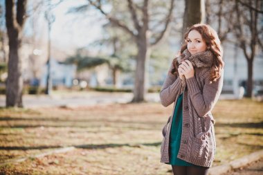 Gizemli güzel genç esmer Bayan portre sevimli yüz ve profesyonel olarak oturmak rahat sıcak tasarımcı kürk ile sonbaharda kıyafetlerle kamera için poz ayartma dudakları ile bahar central park