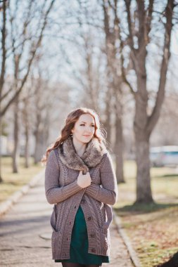 Gizemli güzel genç esmer Bayan portre sevimli yüz ve profesyonel olarak oturmak rahat sıcak tasarımcı kürk ile sonbaharda kıyafetlerle kamera için poz ayartma dudakları ile bahar central park