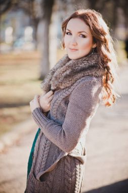 Gizemli güzel genç esmer Bayan portre sevimli yüz ve profesyonel olarak oturmak rahat sıcak tasarımcı kürk ile sonbaharda kıyafetlerle kamera için poz ayartma dudakları ile bahar central park
