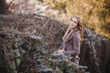 Sonbahar karanlık ormanda kürk boyun yalnız poz sit kamera için tarih ile süslü şık sıcak elbise güzel gerçek lady esmer kıvırcık saçlar ve çok güzel gözleri ile mistik giymiş