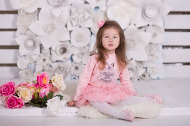 Happyly photosession duvar kağıt çiçeklerle kürk katta modern showroom Studio için kamera için poz gülümseyen pembe elbise pinky etek gömlek giymiş şık brunnete saçlı güzel kız.