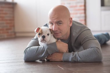 Köpek yavrusu İngilizce bulldog ile yakışıklı cesur adam