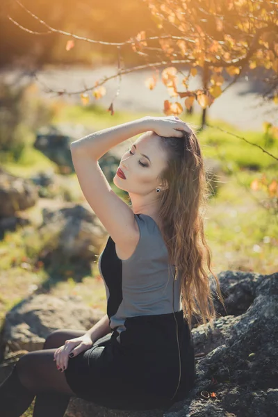 Sexy chica increíble chica ingeniosa elegante vestida con chaqueta de otoño con pelos rubios y pucheros labios rojos con maquillaje cara posando sentarse para la cámara en el parque central primavera bosque pradera — Foto de Stock