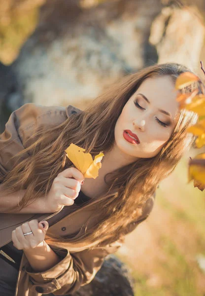 Sexy chica increíble chica ingeniosa elegante vestida con chaqueta de otoño con pelos rubios y pucheros labios rojos con maquillaje cara posando sentarse para la cámara en el parque central primavera bosque pradera — Foto de Stock