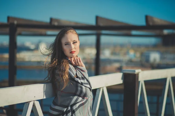 Seductora chica sexy con romántico puchero labios rojos y mejillas meñique usando elegante vestido de chaqueta y pantalones cortos con botas de otoño posando en muelle muelle muelle lado del mar con maquillaje en la cara i episodio romántico — Foto de Stock