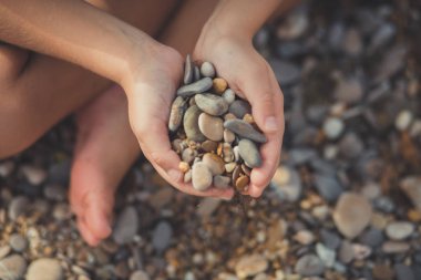 Sahil seyahat spa yaz tatil plaj deniz tarafı sahildeki holding taşlarla odak çocuk eller.