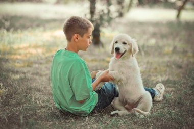 Av köpeği yavru güzel sahne handsom genç çocuk en iyi arkadaş köpek Fildişi beyaz labrador köpek yavrusu ile yaz saati tatil keyfi. Hayaller dünyasında mutlu airily dikkatsiz çocukluk hayatı