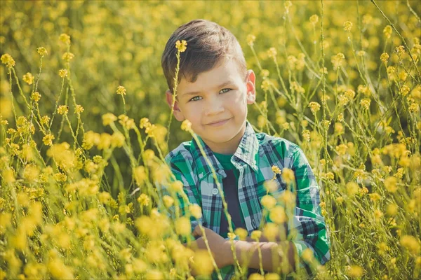 Gut aussehende glückliche Junge Kind genießen posieren Sommerurlaub auf Feld gelben Blumen tragen rustikale Dorf Stil clothes.cute Kind träumt über das zukünftige Leben — Stockfoto