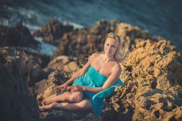 Mujer dama rubia seductora con piernas desnudas sexy hombros y brazos usando vestido abierto azul claro posando disfrutando de tiempo de vacaciones en la playa del mar solo solitario . — Foto de Stock