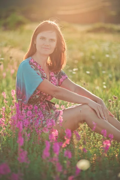 Affascinante adorabile giovane donna capelli castani scuri e occhi verdi tenera posa sexy con fiori corona sulla parte superiore della testa e mazzo enorme di margherita selvaggia camomilla indossando abito elegante . — Foto Stock