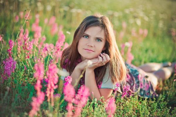 Encantadora joven adorable mujer morena oscura pelos y ojos verdes tierna pose sexy con flores corona en la parte superior de la cabeza y enorme ramo de manzanilla salvaje con vestido elegante . — Foto de Stock