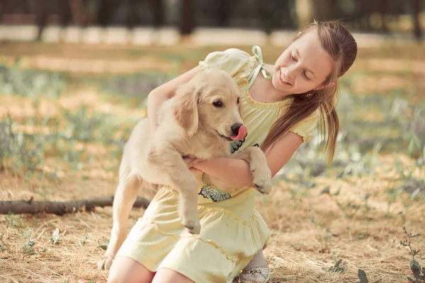 レトリーバーの子犬を素敵なシーンかわいい若い十代の少女犬アイボリー白のラブラドール子犬の親友で夏季休暇をポーズを楽しんでします。子犬との夢の幸せな取り澄まし不注意な幼年期の生活世界 — ストック写真