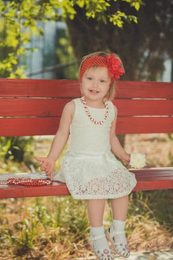 Central park Bahçe giymeye poz retro şık giyinmiş sarışın genç bebek kız çocuk Fransızca couturer beyaz elbise kırmızı bandana ve çelenk