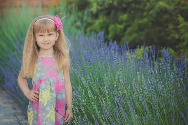 Bionda giovane bambina divertirsi durante le vacanze estive posa sessione di stile di moda vicino alla lavanda verde primavera — Foto Stock