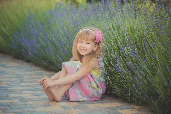 Bionda giovane bambina divertirsi durante le vacanze estive posa sessione di stile di moda vicino alla lavanda verde primavera — Foto Stock