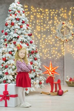 Noel xmas rahat altın studio süslemeleri ile şirin kız ve bol sunar altın çerçeve ve büyük yeşil çam ağacı ile büyük ayna