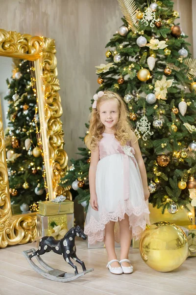 Natal xmas casual ouro estúdio decorações com menina bonito e enorme espelho com quadro dourado presentes de abundância e grande árvore de pinho verde — Fotografia de Stock