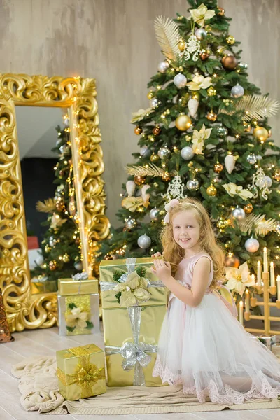 Natal xmas casual ouro estúdio decorações com menina bonito e enorme espelho com quadro dourado presentes de abundância e grande árvore de pinho verde — Fotografia de Stock