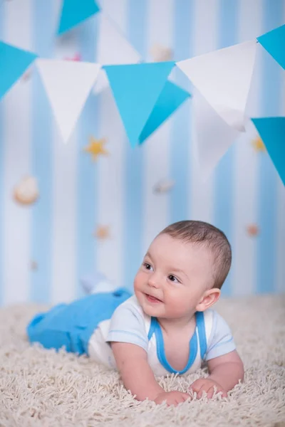 Chłopiec dziecko przystojny śmieszne szczęśliwe dziecko pozowanie na drewnianym stole futro w blue studio — Zdjęcie stockowe