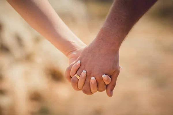 Love hands holding each other in lock of future family close focus picture of man and woman romantic tender touch scene in family stronghold values