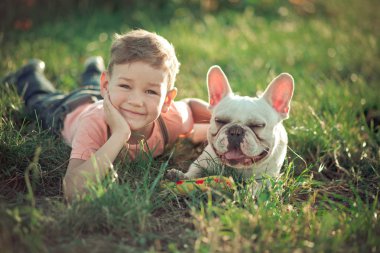 Yakışıklı çocuk çocuk ve boğa köpek köpek yeşil taze yaz central Park'ta birlikte poz arasında dostluk güzel sahne çimen giyen şık giysiler