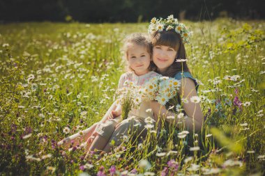 Mutlu güzel annem Bayan daisy haşhaş çiçek çayır üzerinde aile yaz yaşam güzel sahne sevimli küçük kızı ile birlikte poz