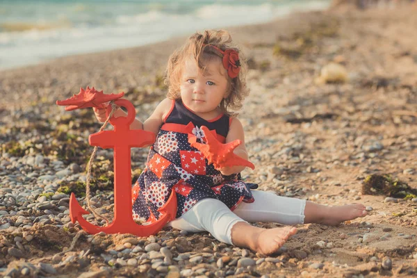 Marvelous dream picture of baby girl with blond hairs blue eyes and pink cheeks posing running on sand beach sea side wearing retro old style colourful clothes — Stock Photo, Image