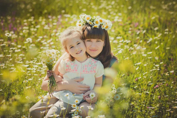 Happy beautiful mother lady posing with her cute little daughter in lovely scene of family summer life on meadow of daisy poppy flowers together — Stock Photo, Image