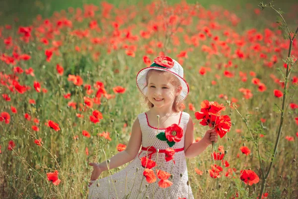 Linda niña rubia joven con estilo vestido de blanco vestido enganchado hecho a mano con sombrero aireado superior posando en el prado de amapolas del bosque Adorable escena —  Fotos de Stock