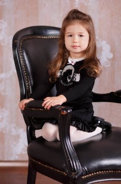 Studio pout dudak ve pembe yanakları ile siyah deri sandalye üzerinde oturan poz beyaz resmi gömlek siyah etekle bir patron gibi genç esmer dolly Bayan kız şık giyinmiş.