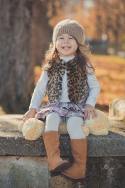 Pin-up çekici genç esmer kızı giyiyor moda şık gri ceket umut ve giyim Sonbahar Bahar park hafta sonu happyly gülümseyen oturma yolu poz izlemek harika bot ile sıcak şapka dolly.