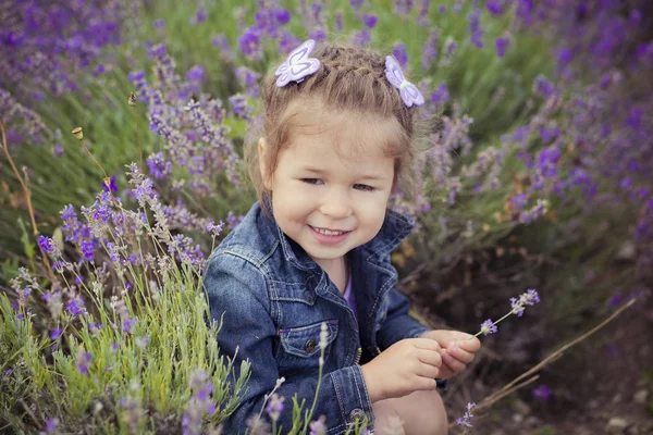 ブルー ジーンズと幸せな笑顔でカメラにポーズをとって紫シャツの美しいかわいい金髪少女の肖像画を閉じます。村 8 月フランス プロヴァンスのラベンダー畑で過ごす幸福時間 — ストック写真