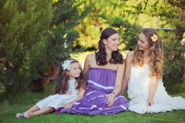 Stunning Brunette blond chestnut blue eyes sisters girls wearing stylish white purple dress enjoying life time together summer sunny day in garden forest on green grass happy smiling — Stock Photo, Image