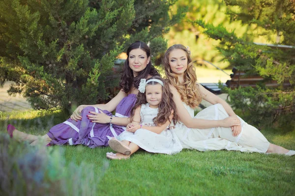 Stunning Brunette blond chestnut blue eyes sisters girls wearing stylish white purple dress enjoying life time together summer sunny day in garden forest on green grass happy smiling — Stock Photo, Image