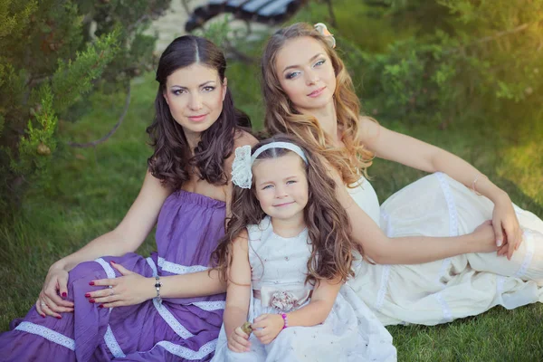 Stunning Brunette blond chestnut blue eyes sisters girls wearing stylish white purple dress enjoying life time together summer sunny day in garden forest on green grass happy smiling — Stock Photo, Image