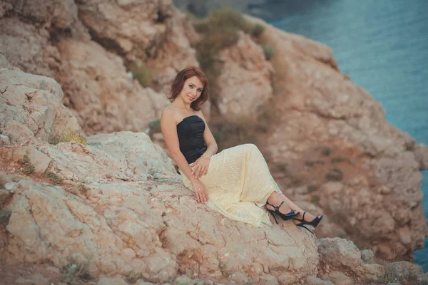 Diario Calendario pelo rojo diosa reina costurera a la espera de su hombre marinero pescador en la playa rocosa capa soñando con el amor y la familia con estilo acogedor blanco negro ropa — Foto de Stock