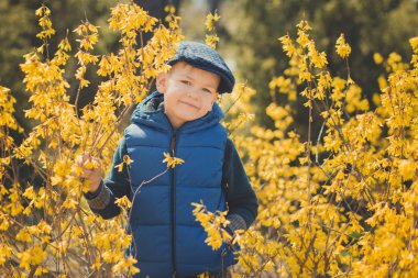 Şık mavi elbise ve şapka sarı çiçekler bahar zaman zevk yakın sevimli yakışıklı çocuk