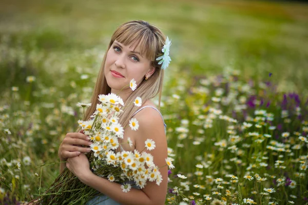 Женщина, наслаждающаяся полем, милая женщина, лежащая в куче цветов, симпатичная девушка, отдыхающая на свежем воздухе, веселящаяся, держащая растение, счастливая барышня и весенняя зеленая природа, гармоничная концепция — стоковое фото