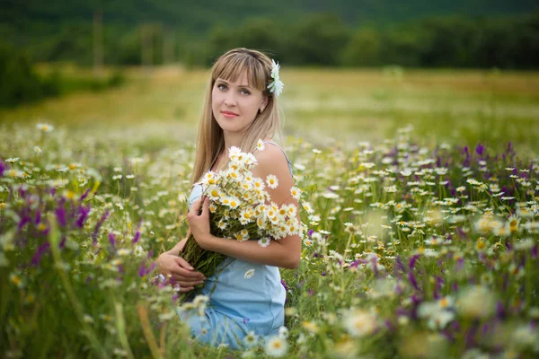 Vacker kvinna njuter av tusensköna fält, trevlig kvinna liggande på äng av blommor, vacker flicka avkopplande utomhus, ha kul, hålla växt, glad ung dam och våren grön natur, harmoni koncept — Stockfoto