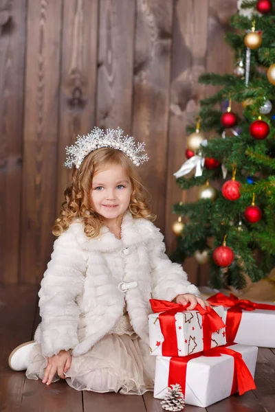 Moda vestido menina senhora com coroa perto da árvore de Natal com presentes — Fotografia de Stock