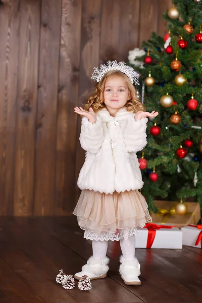 Chica vestida de moda dama con corona cerca del árbol de Navidad con regalos —  Fotos de Stock