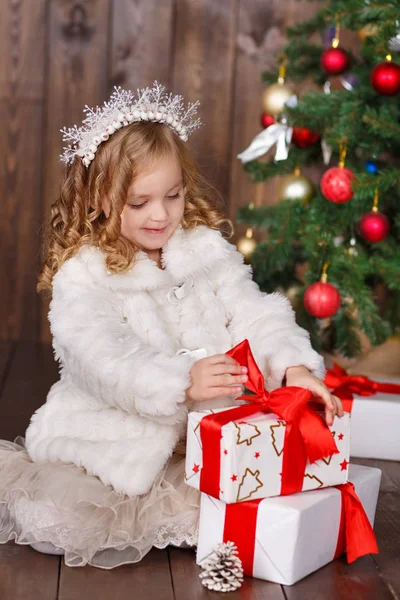Chica vestida de moda dama con corona cerca del árbol de Navidad con regalos — Foto de Stock